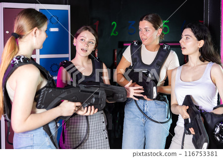 Young girls listen to presenter before start of laser tag game, delve into conditions of game 116753381