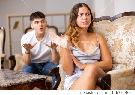 Disgruntled young husband swears at his wife Disgruntled young husband swears at his wife 116753402