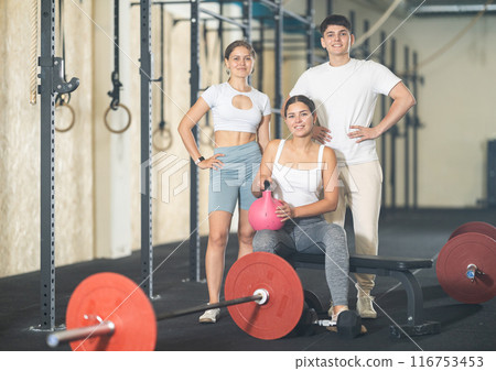 Two young women and guy posing in gym 116753453