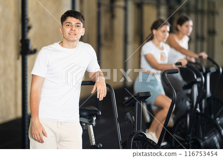 Male trainer in sportswear poses in fitness center gym 116753454