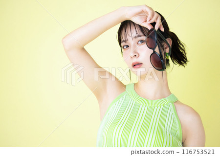 Summer image: Young woman holding sunglasses 116753521