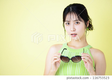 Summer image: Young woman holding sunglasses 116753523
