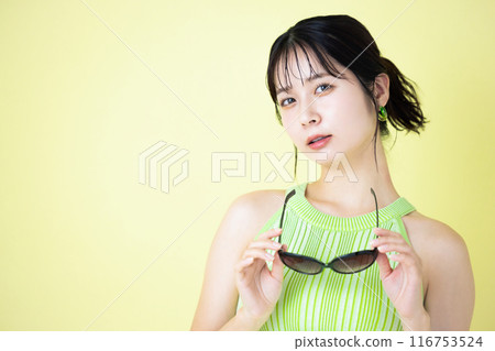 Summer image: Young woman holding sunglasses Summer image: Young woman holding sunglasses 116753524