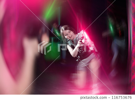 Girls play laser tag, jokingly fight with light weapons Girls play laser tag, jokingly fight with light weapons 116753676