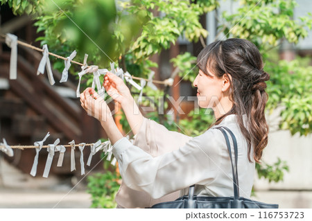 Asian woman drawing a fortune at a shrine Asian woman drawing a fortune at a shrine 116753723