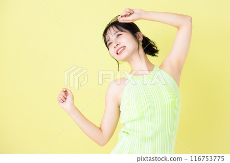 Summer image, yellow background, portrait of a young woman wearing a tank top 116753775