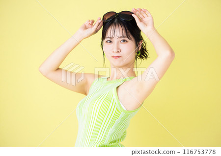 Summer image, yellow background, portrait of a young woman wearing a tank top Summer image, yellow background, portrait of a young woman wearing a tank top 116753778