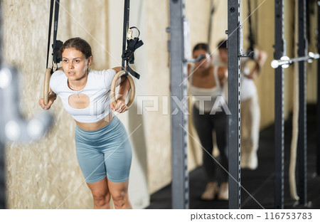 Young woman training on gymnastic rings 116753783