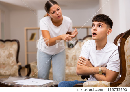 Portrait of upset man sitting while quarrel with wife at home 116753790