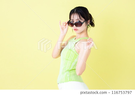 Summer image, yellow background, portrait of a young woman wearing a tank top 116753797