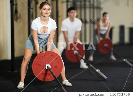 Young woman lifting barbell in gym 116753799