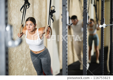Young woman training on gymnastic rings 116753823