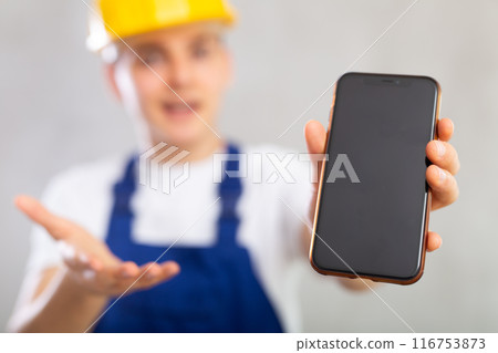 Enthusiastic young worker showing screen of mobile phone excitedly Enthusiastic young worker showing screen of mobile phone excitedly 116753873
