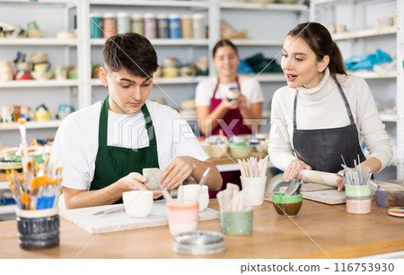 Young woman and young man making pottery Young woman and young man making pottery 116753930