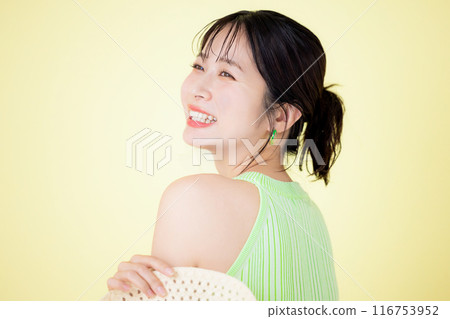 夏季圖像，黃色背景，一位拿著草帽的年輕女子的肖像 116753952