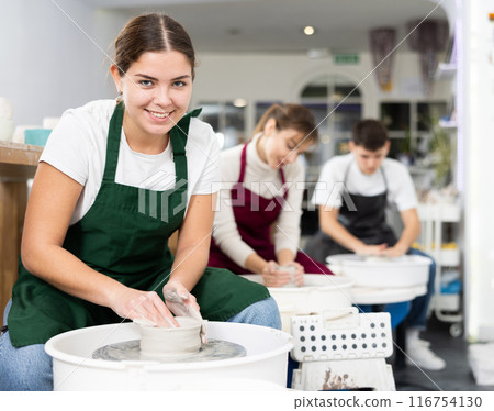 Young woman sculpting product on potter's wheel 116754130