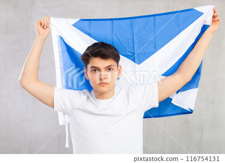Excited young man with Scotland flag rooting for your favorite team Excited young man with Scotland flag rooting for your favorite team 116754131