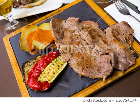 Beef steak with baked potatoes, vegetables, romesco 116754174