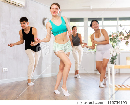 Girl teen perform choreographic exercise and teach energetic mobile social dance groove with friends 116754193