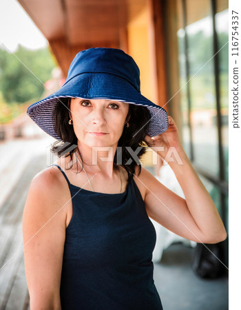 50 years old russian woman in short dress holding her hat on the sumer day 50 years old russian woman in short dress holding her hat on the sumer day 116754337