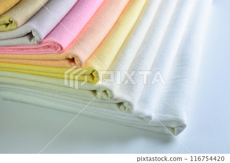 stack of colourful cotton clothes, pile of clothing on white background 116754420