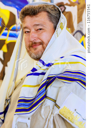 Rabbi wearing traditional Jewish clothing in synagogue during prayer 116755541