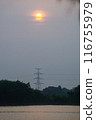high voltage electricity tower on the hill behind the lake 116755979