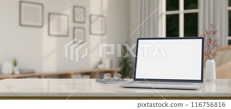 A laptop computer mockup, eyeglasses, and a book on a white marble table in a minimal white room. A laptop computer mockup, eyeglasses, and a book on a white marble table in a minimal white room. 116756816