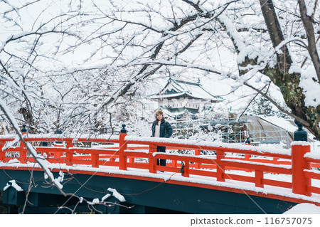 Woman tourist sightseeing Hirosaki Castle in winter, happy traveler travel Hirosaki city, Aomori Prefecture, Tohoku, Japan. Landmark and famous for tourist attraction. Japan travel and vacation Woman tourist sightseeing Hirosaki Castle in winter, happy traveler travel Hirosaki city, Aomori Prefecture, Tohoku, Japan. Landmark and famous for tourist attraction. Japan travel and vacation 116757075