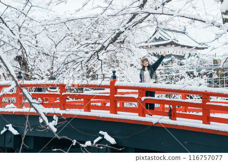 Woman tourist sightseeing Hirosaki Castle in winter, happy traveler travel Hirosaki city, Aomori Prefecture, Tohoku, Japan. Landmark and famous for tourist attraction. Japan travel and vacation Woman tourist sightseeing Hirosaki Castle in winter, happy traveler travel Hirosaki city, Aomori Prefecture, Tohoku, Japan. Landmark and famous for tourist attraction. Japan travel and vacation 116757077