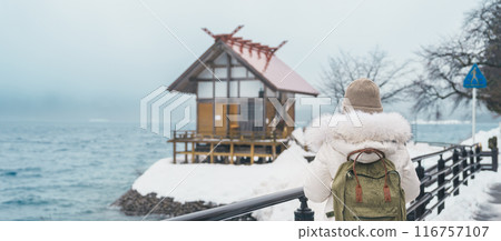 Woman tourist sightseeing Kansa Shrine and Lake Tazawa in winter. Traveler travel in Semboku city, Akita Prefecture, Japan. Landmark for tourist attraction in Tohoku region. Japan travel and vacation 116757107