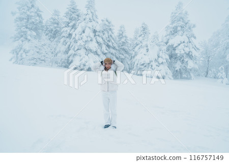 Woman tourist sightseeing Snow monster in Winter day at Mount Zao, Yamagata prefecture, Japan. Happy Traveler walking on powder snow covered in frosty weather. Travel, Adventure and Vacation Woman tourist sightseeing Snow monster in Winter day at Mount Zao, Yamagata prefecture, Japan. Happy Traveler walking on powder snow covered in frosty weather. Travel, Adventure and Vacation 116757149