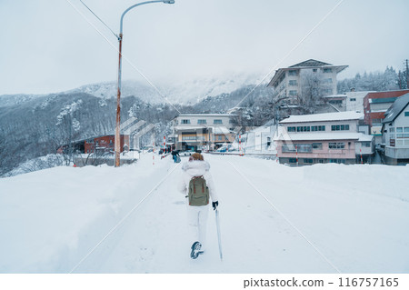 Woman tourist sightseeing Snow fall in Winter day at Zao Onsen, Yamagata prefecture, Japan. Happy Traveler walking on powder snow covered in frosty weather. Travel, Adventure and Vacation Woman tourist sightseeing Snow fall in Winter day at Zao Onsen, Yamagata prefecture, Japan. Happy Traveler walking on powder snow covered in frosty weather. Travel, Adventure and Vacation 116757165