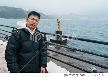 man tourist sightseeing golden Tatsuko statue and Lake Tazawa. Traveler travel in Semboku city, Akita Prefecture, Japan. Landmark for tourist attraction in Tohoku Region. Japan travel and vacation man tourist sightseeing golden Tatsuko statue and Lake Tazawa. Traveler travel in Semboku city, Akita Prefecture, Japan. Landmark for tourist attraction in Tohoku Region. Japan travel and vacation 116757186