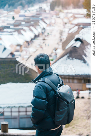 man tourist sightseeing Ouchi Juku ancient farmer house village with snow in winter, Traveler travel in Shimogo town, Minamiaizu, Fukushima Prefecture, Tohoku Region, Japan. Landmark and vacation 116757189