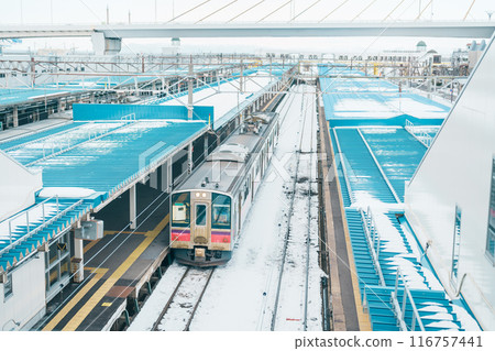 Pink local train in winter at Aomori railway station platform,  in the city of Aomori in Aomori Prefecture, Japan. 116757441