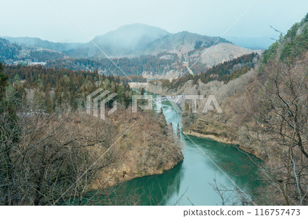 Panoramic View of Japan local train with Tadami river and bridge. Tadami Railway Line in The Valley at Mishima Machi, Aizu, Fukushima Prefecture, Japan. Landmark and iconic spot for tourist attraction 116757473