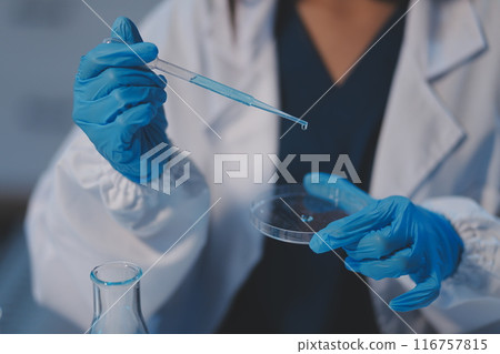 Group of dedicated scientist conduct chemical experiment in medical laboratory, carefully drop precise amount of liquid from pipette into test tube for vaccine drug or antibiotic development. Neoteric Group of dedicated scientist conduct chemical experiment in medical laboratory, carefully drop precise amount of liquid from pipette into test tube for vaccine drug or antibiotic development. Neoteric 116757815