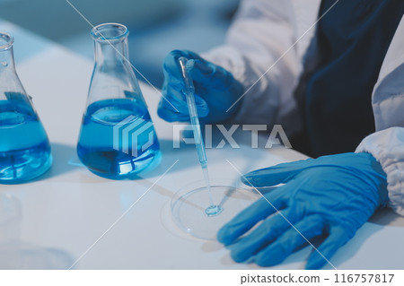 Group of dedicated scientist conduct chemical experiment in medical laboratory, carefully drop precise amount of liquid from pipette into test tube for vaccine drug or antibiotic development. Neoteric Group of dedicated scientist conduct chemical experiment in medical laboratory, carefully drop precise amount of liquid from pipette into test tube for vaccine drug or antibiotic development. Neoteric 116757817