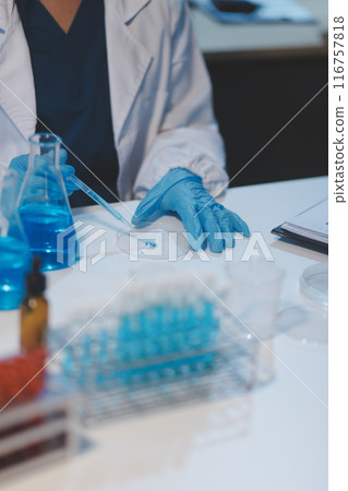 Group of dedicated scientist conduct chemical experiment in medical laboratory, carefully drop precise amount of liquid from pipette into test tube for vaccine drug or antibiotic development. Neoteric Group of dedicated scientist conduct chemical experiment in medical laboratory, carefully drop precise amount of liquid from pipette into test tube for vaccine drug or antibiotic development. Neoteric 116757818