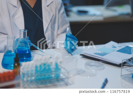 Group of dedicated scientist conduct chemical experiment in medical laboratory, carefully drop precise amount of liquid from pipette into test tube for vaccine drug or antibiotic development. Neoteric Group of dedicated scientist conduct chemical experiment in medical laboratory, carefully drop precise amount of liquid from pipette into test tube for vaccine drug or antibiotic development. Neoteric 116757819