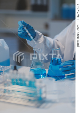 Group of dedicated scientist conduct chemical experiment in medical laboratory, carefully drop precise amount of liquid from pipette into test tube for vaccine drug or antibiotic development. Neoteric Group of dedicated scientist conduct chemical experiment in medical laboratory, carefully drop precise amount of liquid from pipette into test tube for vaccine drug or antibiotic development. Neoteric 116757823