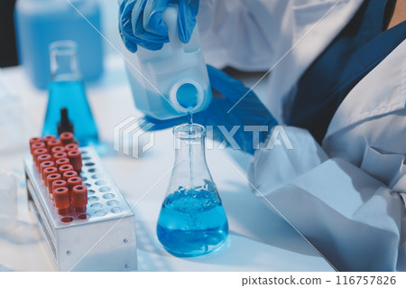 Group of dedicated scientist conduct chemical experiment in medical laboratory, carefully drop precise amount of liquid from pipette into test tube for vaccine drug or antibiotic development. Neoteric Group of dedicated scientist conduct chemical experiment in medical laboratory, carefully drop precise amount of liquid from pipette into test tube for vaccine drug or antibiotic development. Neoteric 116757826