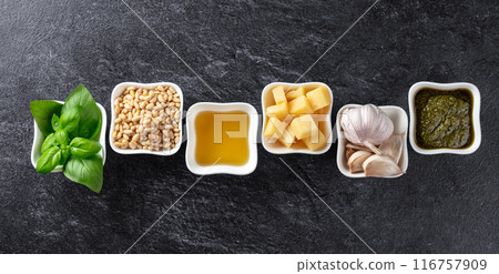 Traditional Italian pesto recipe on a dark stone background. 116757909