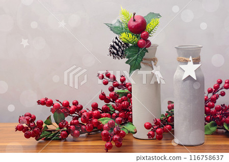 Christmas decoration on table. Branch with red berries and decorative vases. Christmas decoration on table. Branch with red berries and decorative vases. 116758637