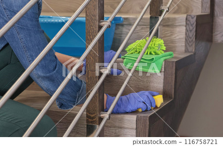 Woman in rubber gloves wash laminate stairs in house. Cleaning and cleanliness, detergents.  116758721