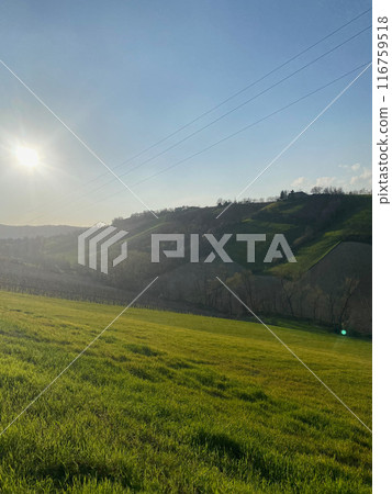 Sun setting over rolling hills and power lines Sun setting over rolling hills and power lines 116759518