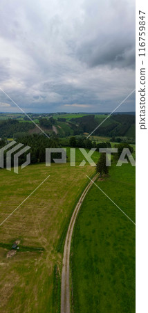 Experience the beauty of countryside from above with rolling hills and a dramatic sky Experience the beauty of countryside from above with rolling hills and a dramatic sky 116759847