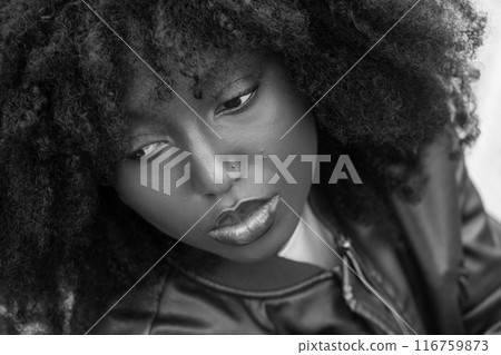 Contemplative portrait of a woman with curly hair in monochrome, highlighting artistic beauty Contemplative portrait of a woman with curly hair in monochrome, highlighting artistic beauty 116759873