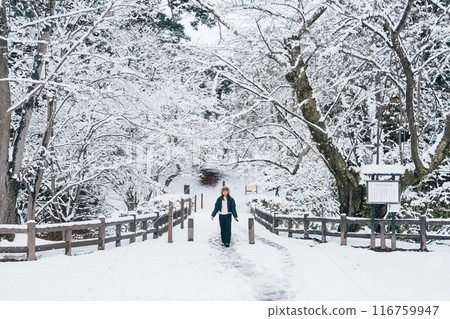 Traveler with Sweater and backpack walking on snow covered forest in frosty weather. Winter Travel, Adventure, Exploring and Vacation concept Traveler with Sweater and backpack walking on snow covered forest in frosty weather. Winter Travel, Adventure, Exploring and Vacation concept 116759947